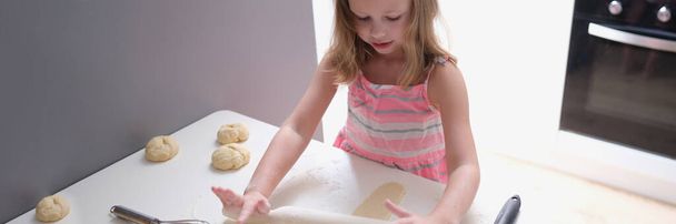 Child girl with rolling pin for baking cookies for dough. Children cooking concept - Foto, Bild