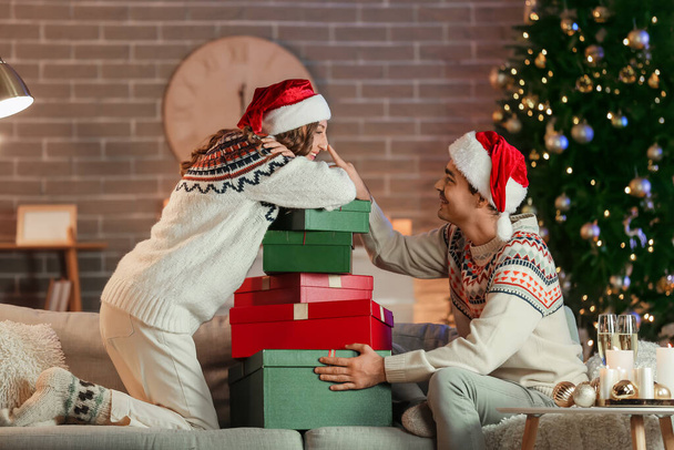 Young couple in love with presents at home on Christmas eve - Foto, Bild