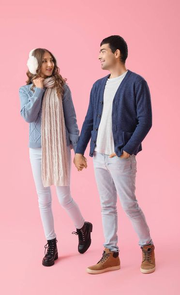 Молодая пара влюбленных, держась за руки на розовом фоне - Фото, изображение