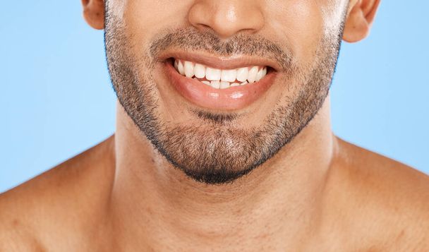 Teeth, mouth and beard of a man with a smile for dental, health and wellness against a blue studio background. Healthcare, lips and face of a happy and clean model with results from care for tooth. - Φωτογραφία, εικόνα