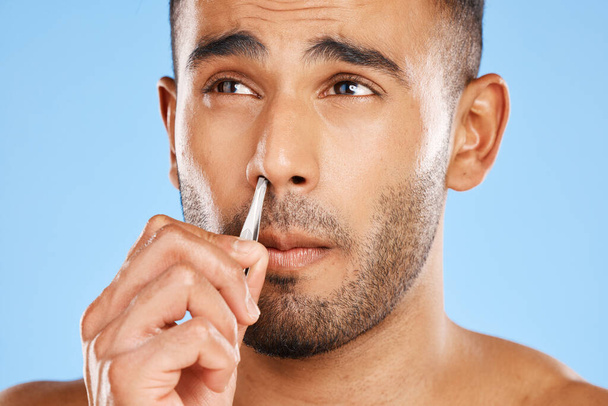 Mies, nenän hoito ja kasvojen hoito kauneudenhoito sininen tausta studiossa. Nuorten miesten kasvojen, kosmeettisen kehon ihonhoidon terveellinen elämäntapa ja käsien nenän hygienia henkilökohtainen hoito. - Valokuva, kuva