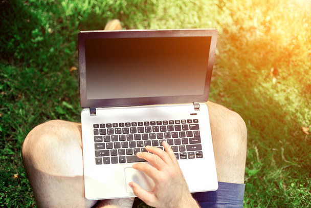 Mladý blogger sedí na trávě a pracuje s laptopem. Rozumím. Světlice - Fotografie, Obrázek