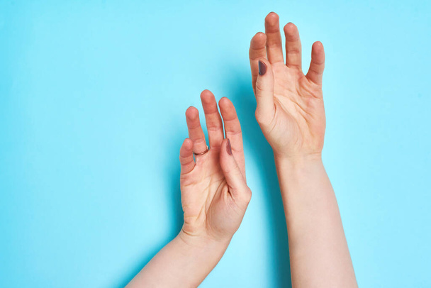Σύρετε τα χέρια σας στο ρυθμό της ζωής. Στιγμιότυπο από ένα αγνώριστο πρόσωπο χέρια πάνω σε μπλε φόντο - Φωτογραφία, εικόνα
