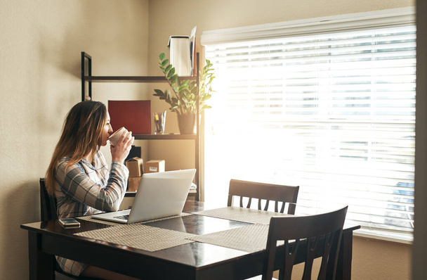 Güne kahve, tefekkür ve bağlantı ile başlıyor. Genç bir kadın kahve içiyor ve sabahları evde dizüstü bilgisayar kullanıyor. - Fotoğraf, Görsel