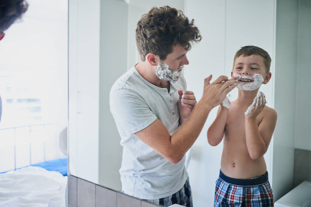 Falhaste uma mancha. um pai ensinando seu filho pequeno como se barbear no banheiro em casa - Foto, Imagem