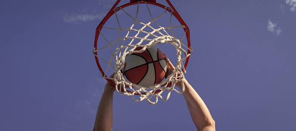 dunk in basket. slam dunk in motion. summer activity. smiling man with basketball ball. Horizontal poster design. Web banner header, copy space - Foto, afbeelding