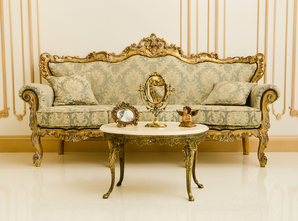 Барокко золотой диван, стол и зеркала в роскошном номере
 - Фото, изображение