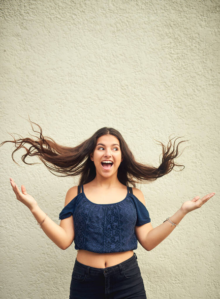 Get excited about your beautiful life. Portrait of a happy teenage girl posing against a wall outside - Foto, afbeelding