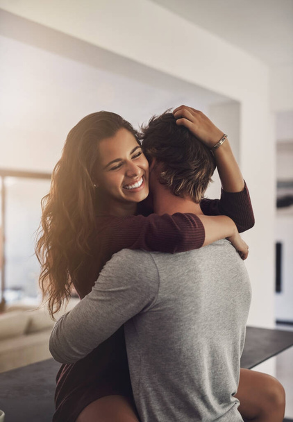 Happiness happens when Im with you. an affectionate young couple hugging in the kitchen at home - Foto, imagen