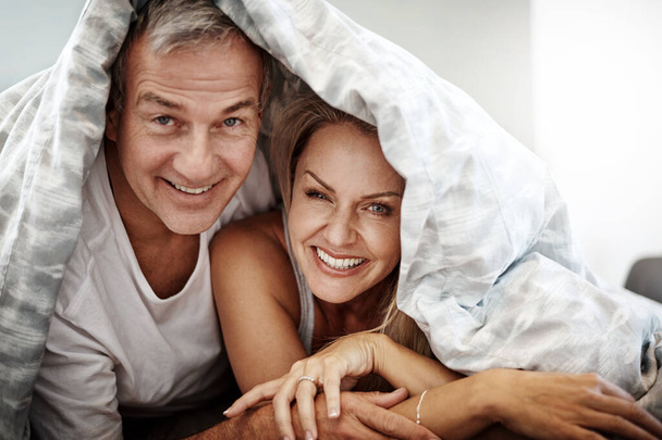 We love a weekend lie-in. an affectionate couple spending the day in bed - Foto, afbeelding