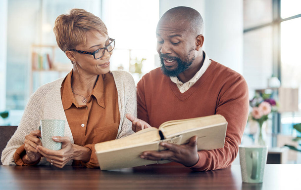 Christian, prayer or black couple reading bible book for faith, worship or bible study in kitchen or living room. Coffee, happy or man and woman for education, study or black family for church Sunday. - 写真・画像