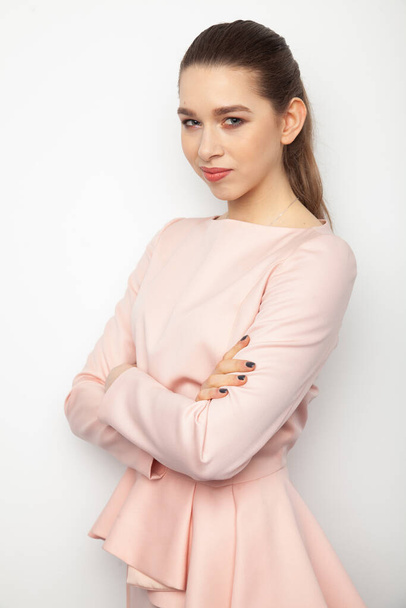 Porträt einer attraktiven jungen Erwachsenen attraktive brünette Geschäftsfrau in rosa Kleid isoliert auf weißem Hintergrund - Foto, Bild