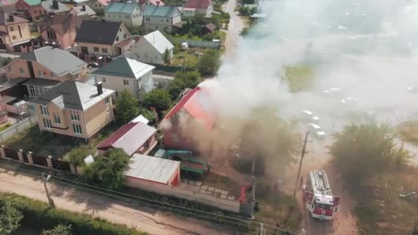 Luchtvideobeelden van een drone. Vlucht over woonwijk. Er komt grijze rook uit het huisje. Vuur. Weg. Hoge kwaliteit 4k beeldmateriaal - Video