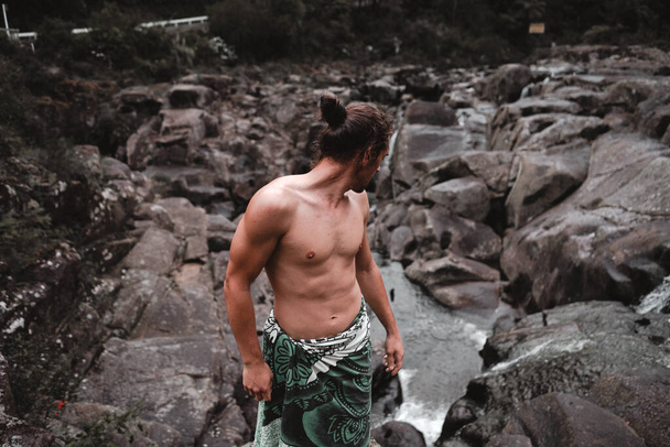 bare-chested young guy on top of the rocks - Lifestyle concept - Фото, изображение
