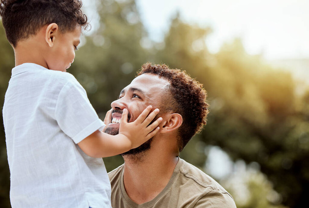 Dad, boy touch face in outdoor park or backyard for summer bonding, happiness together and sunshine. Father son, happy black man in nature for love smile and quality time with child. - Photo, Image