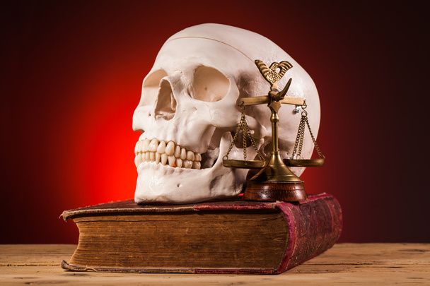Human scull  scales of justice and old book - Foto, afbeelding