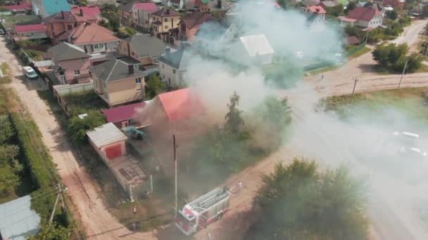 Bir yangının hava görüntüsü. Kırmızı ev. Camlardan duman çıkıyor. Konut alanı. Acil durum çağrısı. 4k drone görüntüsü. Yüksek kalite 4k görüntü - Video, Çekim