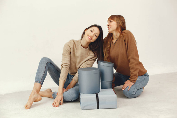 Women with presents. Girls in a brown sweater. Ladies in a studio. - Photo, Image