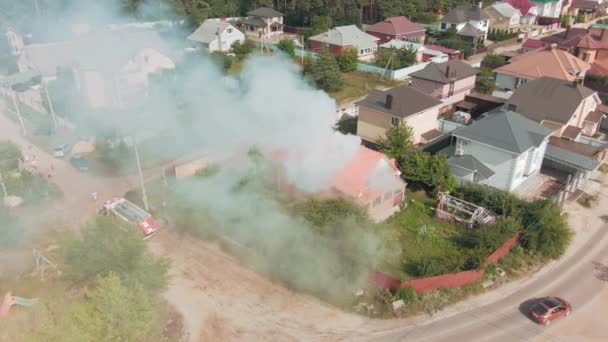 Flight over a burning house. Gray smoke. Fire trucks. Private houses. Emergency. Fire. Aerial drone footage. Top view. High quality 4k footage - Footage, Video