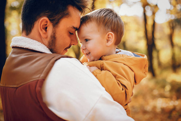 Family have fun in a autumn park. Handsome fathe with little son - 写真・画像