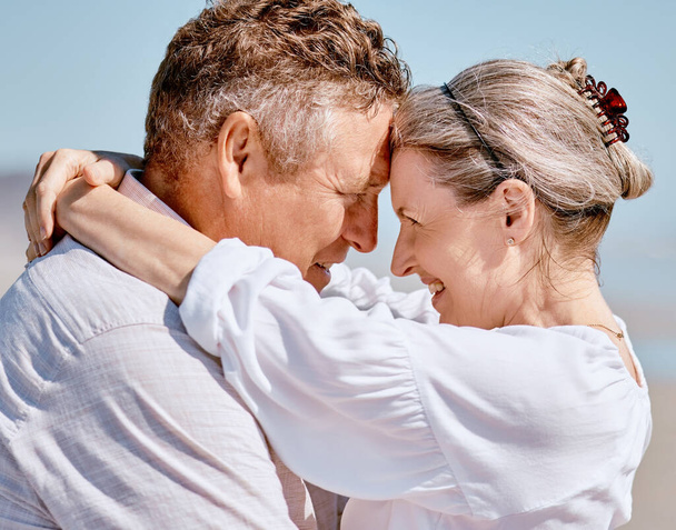 Love, romance and beach with a senior couple hugging outdoor in nature while enjoying a retirement vacation. Travel, summer and together with a mature man and woman pensioner bonding on the coast. - Foto, Bild