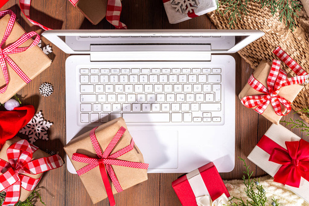 Üzerinde Noel hediyesi kutuları olan dizüstü bilgisayar tahta arka planda. Hediyeli defter, köknar ağacı ve kış dekoru. Noel ve Yeni Yıl için Hazırlık - Fotoğraf, Görsel