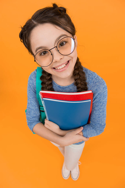 What would you like to read. Happy library reader yellow background. Little girl hold library books. Smart bookworm. School library. Knowledge and information. Bookstore. Its all about books. - Foto, imagen