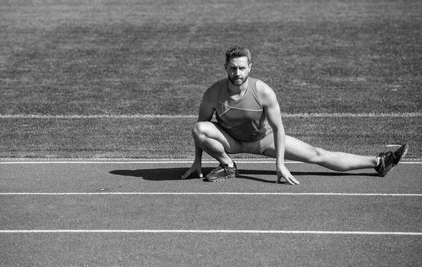 Fitness man. fitness gym outdoor. muscular athletic guy training. sport. male stretch muscles. sportsman relax. athlete train his flexibility. be flexible. man doing stretching exercise on stadium. - Foto, Imagem