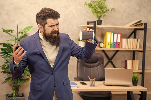 Unhappy businessman turning empty disposable cup during coffee break in office, takeaway. - Foto, Bild