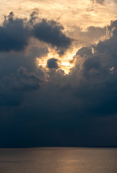 Схід сонця в морі з хмарами штормових хмар і помаранчевий колір. Морська миша зранку. Сонячні промені в океані - Фото, зображення
