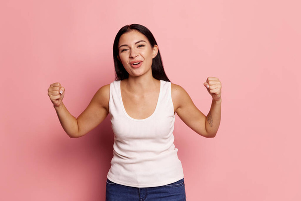 I won. Winning success happy woman celebrating being a winner. Dynamic image of caucasian female model on pink studio background. Victory, delight concept. Human facial emotions concept. Trendy colors - Foto, Imagem