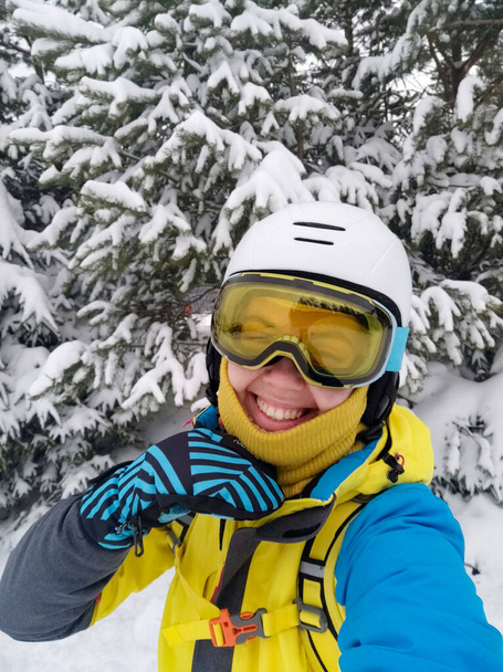 улыбающаяся женщина делает селфи в лыжном снаряжении - Фото, изображение