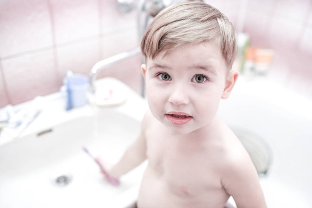 Happy kid or child brushing teeth in bathroom. Dental hygiene. Going to sleep. Close up shot - 写真・画像