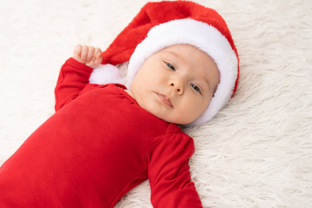 Close up cute newborn baby girl with santa hat lying outdoors - Zdjęcie, obraz