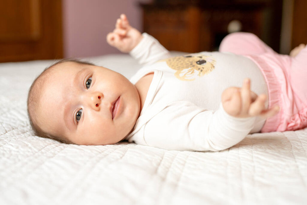 Dokuma battaniyesinin üzerinde yeni doğmuş bir kız bebek. Yatakta uzanmış gözleri açmış.. - Fotoğraf, Görsel