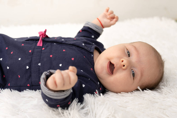 新生児の女の子のテクスチャブランケット、毛布の上に横たわる、目を開けた. - 写真・画像