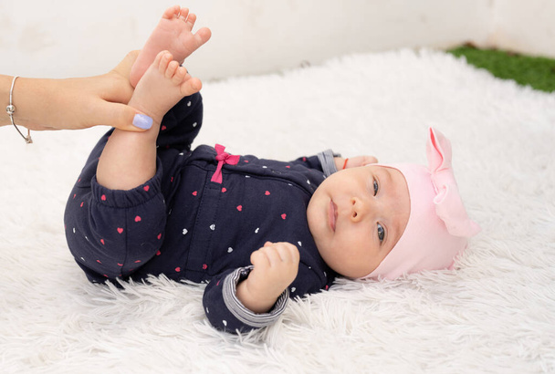 Neugeborenes Mädchen auf Texturdecke, auf Decke liegend, geöffnete Augen. - Foto, Bild