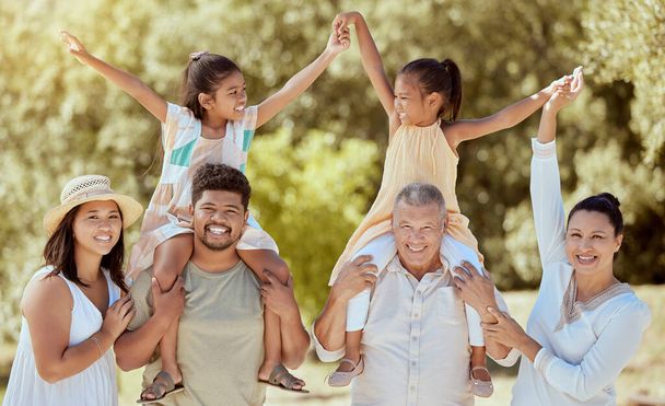 Family, love and outdoor, generations in park have fun out in nature, big family together and smile in portrait. Parents, grandparents and children bonding, arms up and happiness with care - Photo, Image