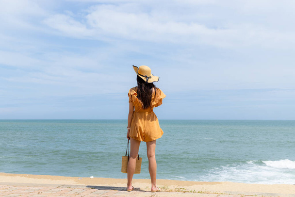 Туристическая женщина стоит на пляже - Фото, изображение