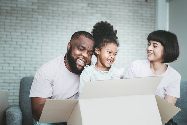 Οικογένεια, Αφρο-Αμερικανός πατέρας, Ασιάτισσα μητέρα και 5χρονη κόρη, είναι ευτυχισμένοι μαζί Από τη μετακόμιση ή τη μετεγκατάσταση σε ένα νέο σπίτι, στην οικογένεια και την έννοια της σχέσης. - Φωτογραφία, εικόνα