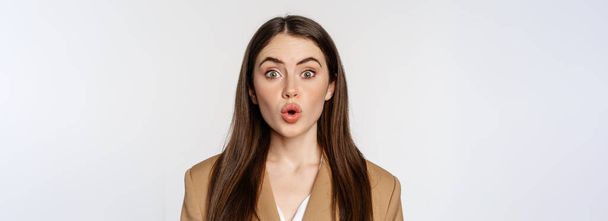 Close up portrait of surprised, amazed businesswoman, say wow, staring impressed at camera, fascinated face expression, white background. - Foto, Imagen
