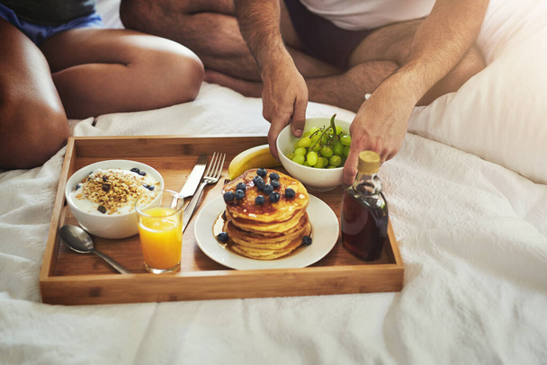 Aamiainen sängyssä on aina hyvä idea. Korkea kulma laukaus tunnistamaton pari nauttia aamiaisen sängyssä yhdessä kotona - Valokuva, kuva