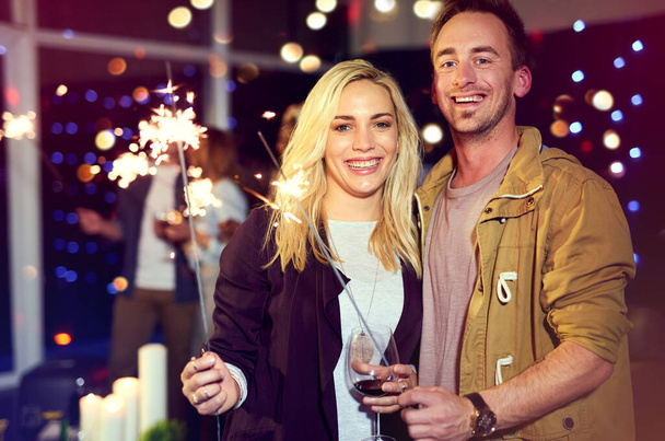 Cheerful celebrations with the best person. Portrait of an attractive young couple having fun with sparklers at a nightclub - Photo, Image