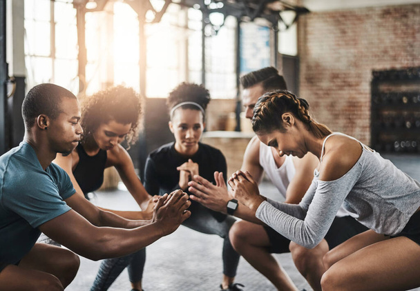 Kniebeugen - Das ultimative Unterkörpertraining. eine Gruppe junger Leute bei Kniebeugen während ihres Trainings in einem Fitnessstudio - Foto, Bild