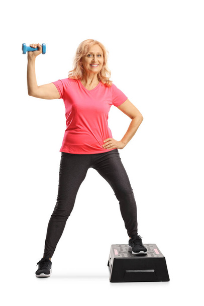 Full length portrait of a mature woman exercising step aerobic isolated on white background - Fotografie, Obrázek