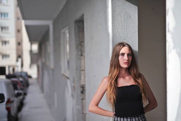 portrait of young woman leaning against a wall in the city - Fotoğraf, Görsel