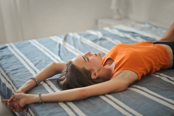 young woman is resting on the bed - Foto, afbeelding