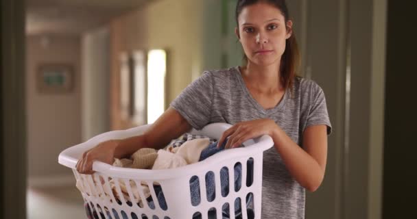 Hezká běloška doma nosí košík čistého oblečení. Portrét mladé ženy v domácnosti nebo matky, jak dělají domácí práce. 4k - Záběry, video