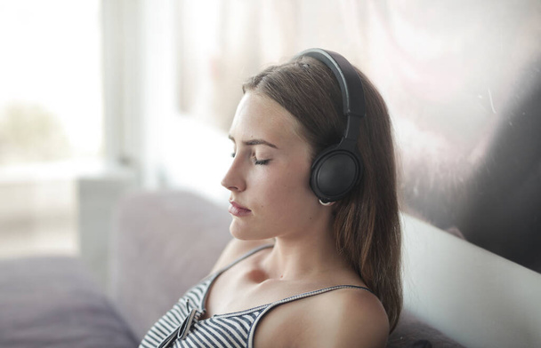 jeune femme écoute de la musique avec des écouteurs - Photo, image