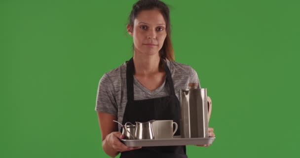 Nieszczęśliwy kobiecy serwer niosący tacę z filiżanką kawy na zielonym ekranie. Poważna młoda kelnerka trzymająca tacę z napojem kawowym i kolbą termalną na zielonym ekranie. 4k - Materiał filmowy, wideo